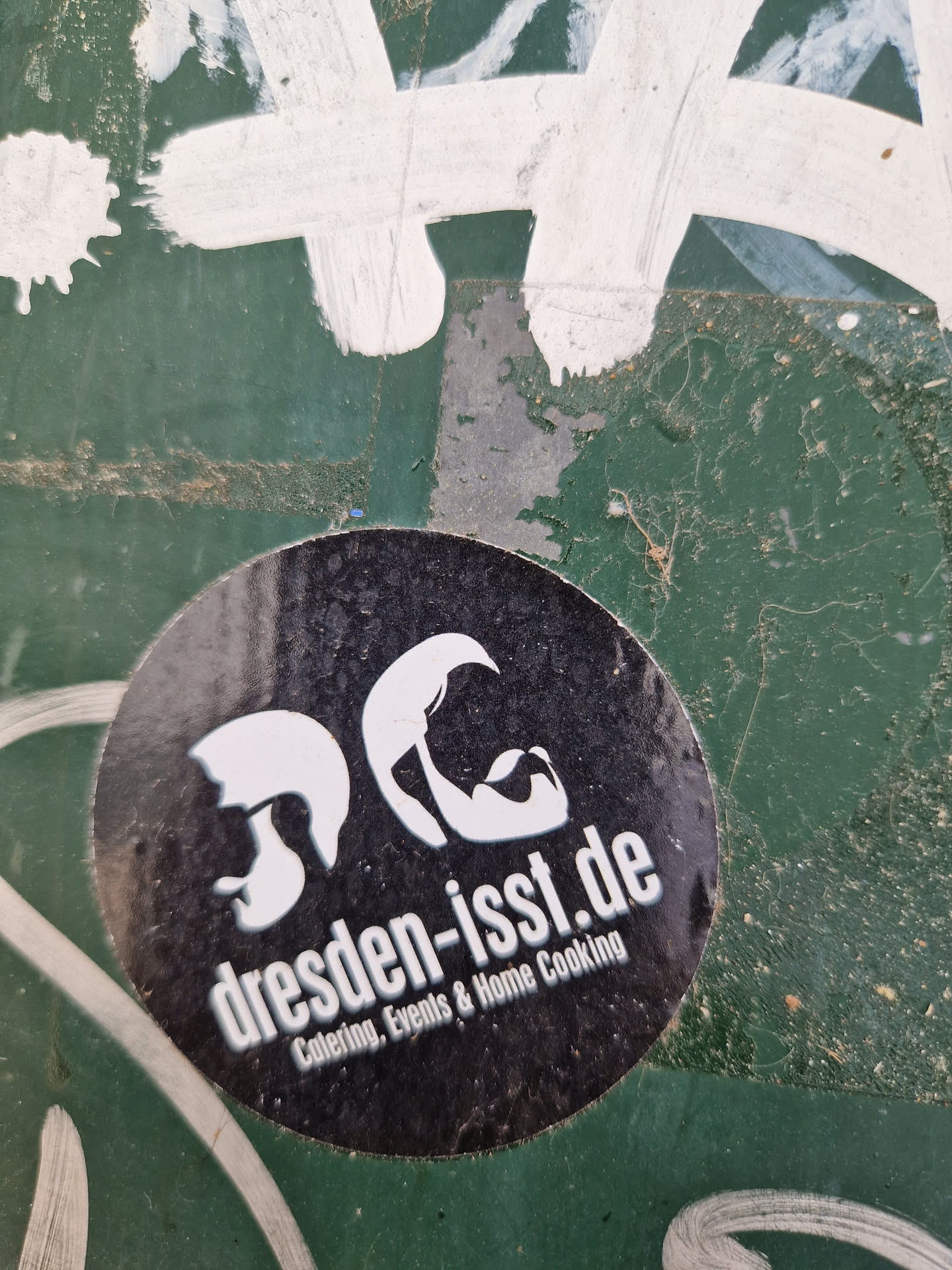 Round black and white sticker with the text "dresden-isst.de" and the description "Catering, Events & Home Cooking".  It also features two stylized faces.