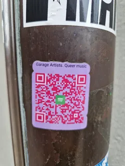A purple sticker with a QR code leading to a Spotify playlist. The text on the sticker reads "Garage Artists. Queer music".