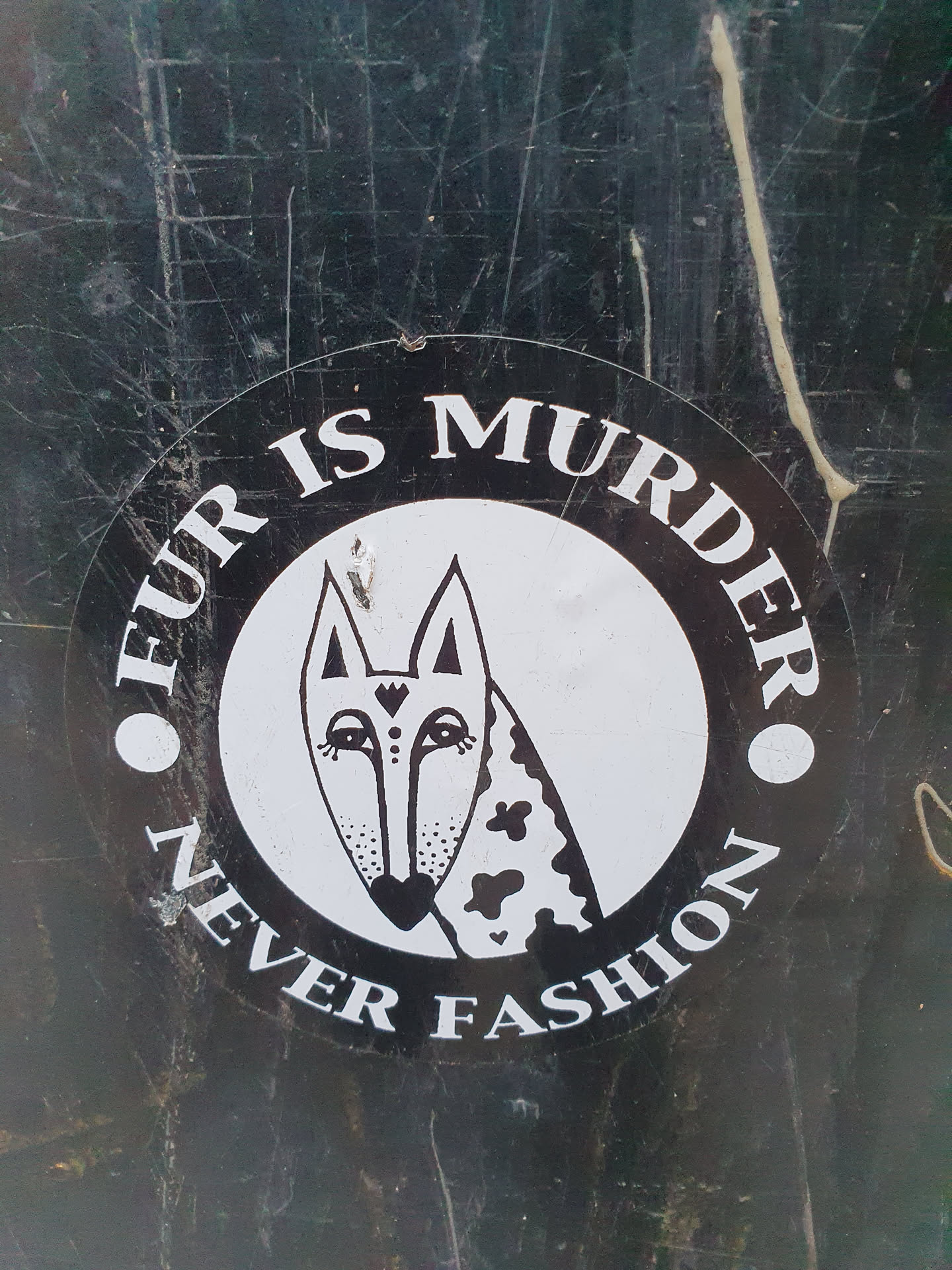 Black and white round sticker with an illustration of a fox and the text "Fur is murder, never fashion".