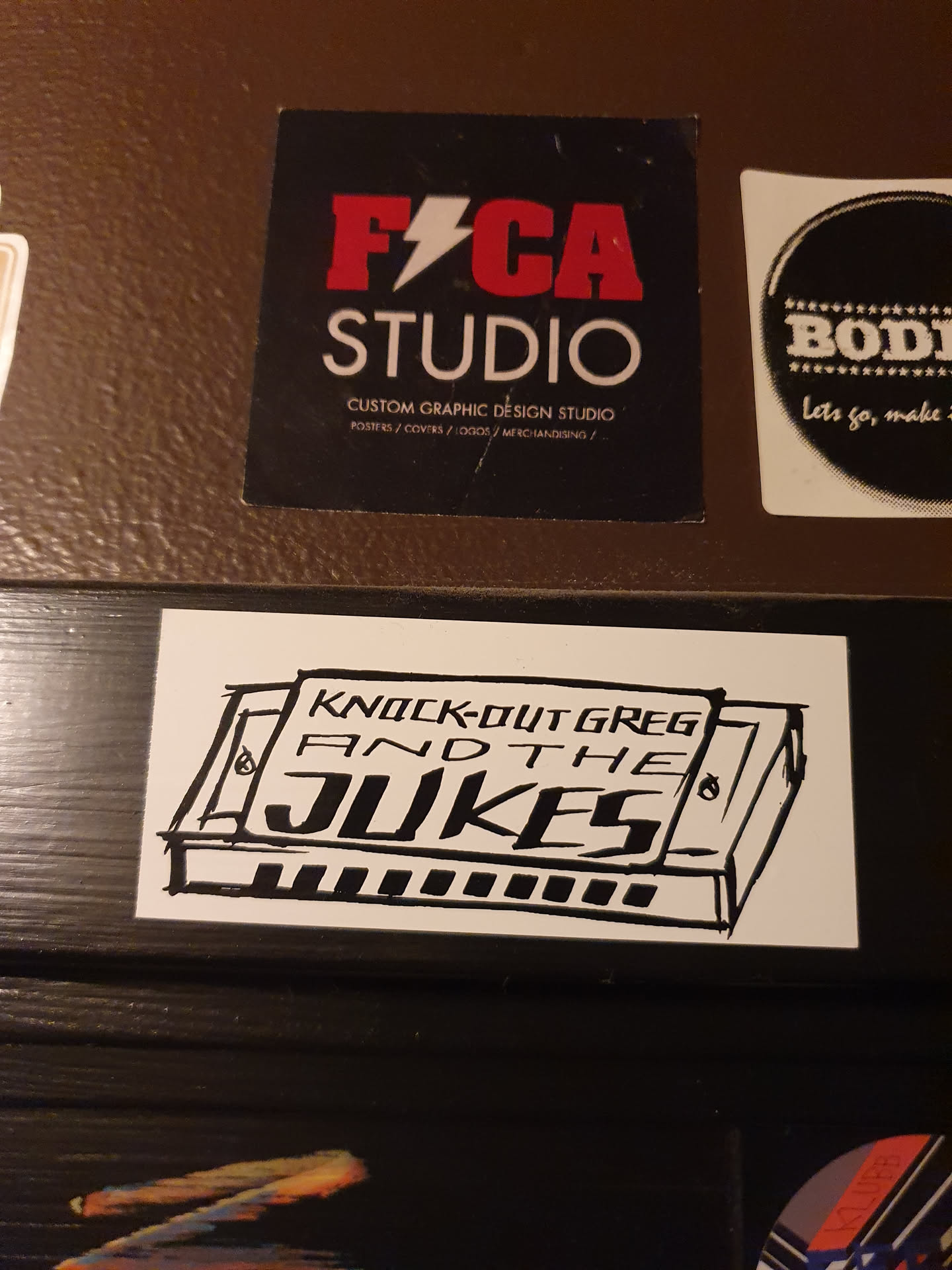 A sticker featuring a hand-drawn illustration of a harmonica with the band's name written above it. The art style is simple and slightly rough, giving it a handmade feel. The sticker is white with black ink.