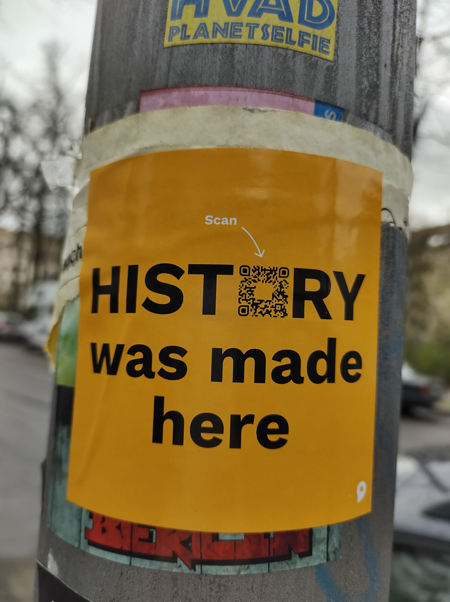 A yellow sticker with a QR code. The text on the sticker says 'Scan' and 'HISTORY was made here'.