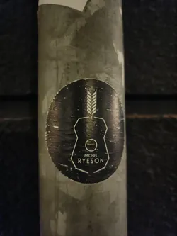 A black and white sticker with a unique design featuring a wheat stalk and geometric shapes. The artist's name, Michel Ryeson, is prominently displayed.