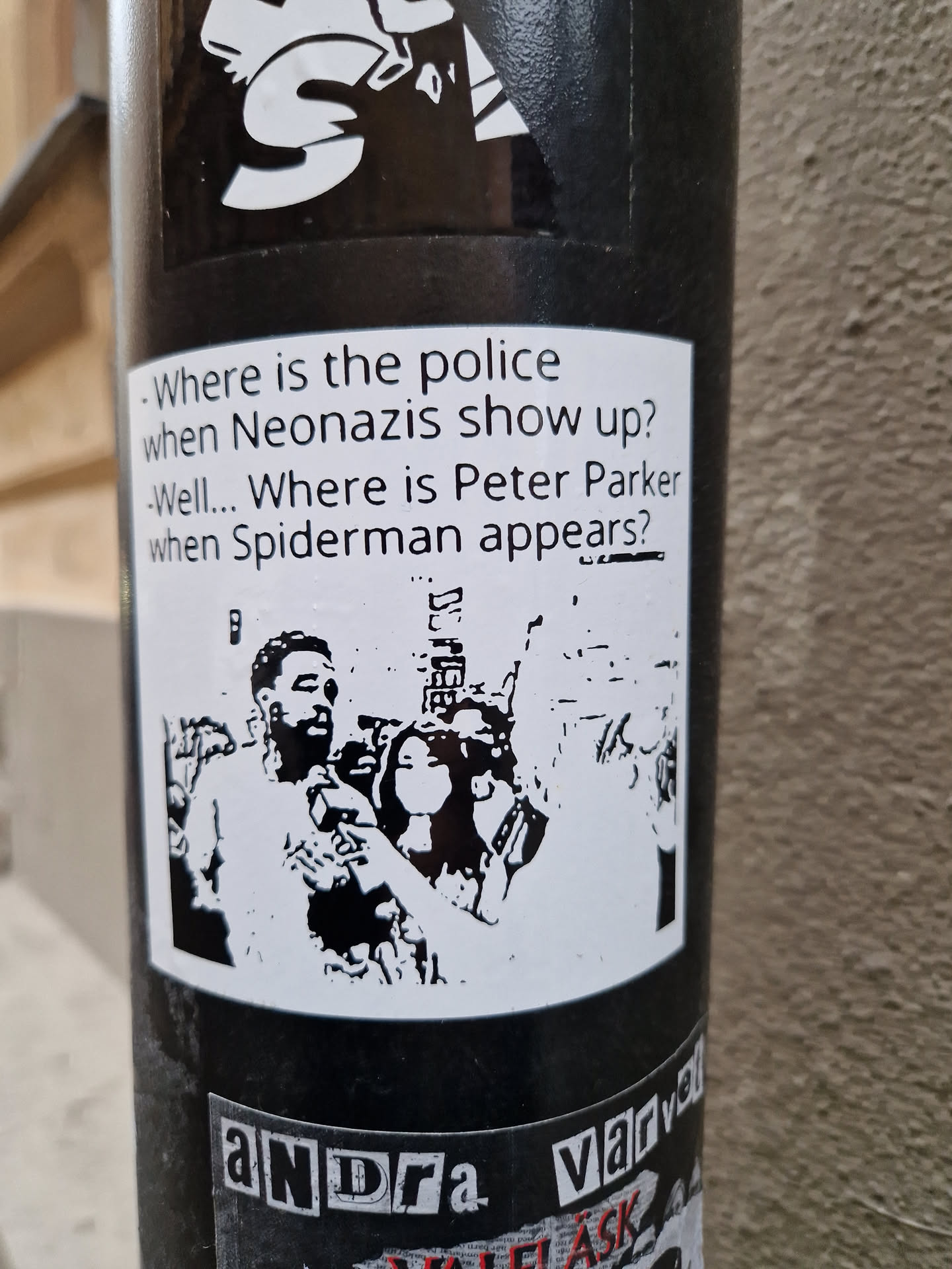 Black and white sticker featuring a stylized image of a man and a woman, possibly referencing the lack of police presence during neo-nazi demonstrations compared to the presence of authorities during other public events.  The sticker also includes text posing this comparison as a rhetorical question. 