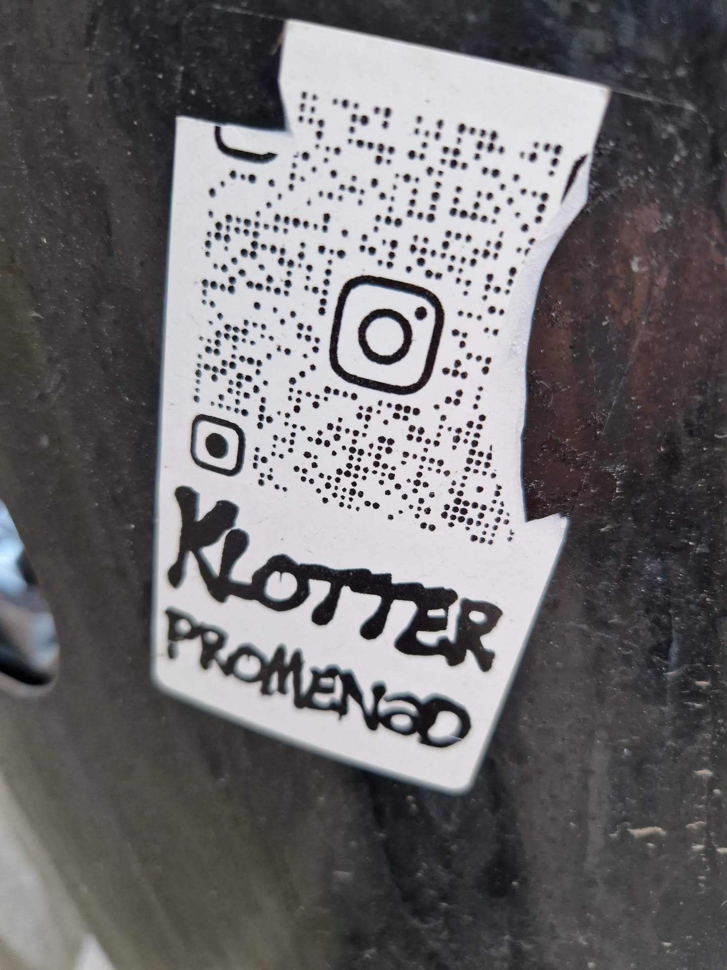 Black and white sticker with a QR code linking to Instagram and the text 'Klotterpromenad' written in a graffiti style.