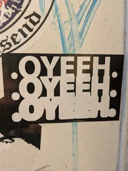 A black and white sticker with the text "OYEH" repeated three times, arranged vertically with slight variations in style. The text is bold and uppercase, printed on a black background with white lettering. The sticker has a simple, graphic design.