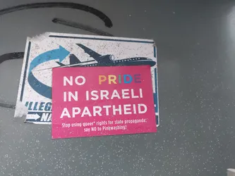 A sticker with a plane and text protesting the use of LGBTQ+ rights to promote Israeli policies.  The sticker advocates saying no to Pinkwashing.