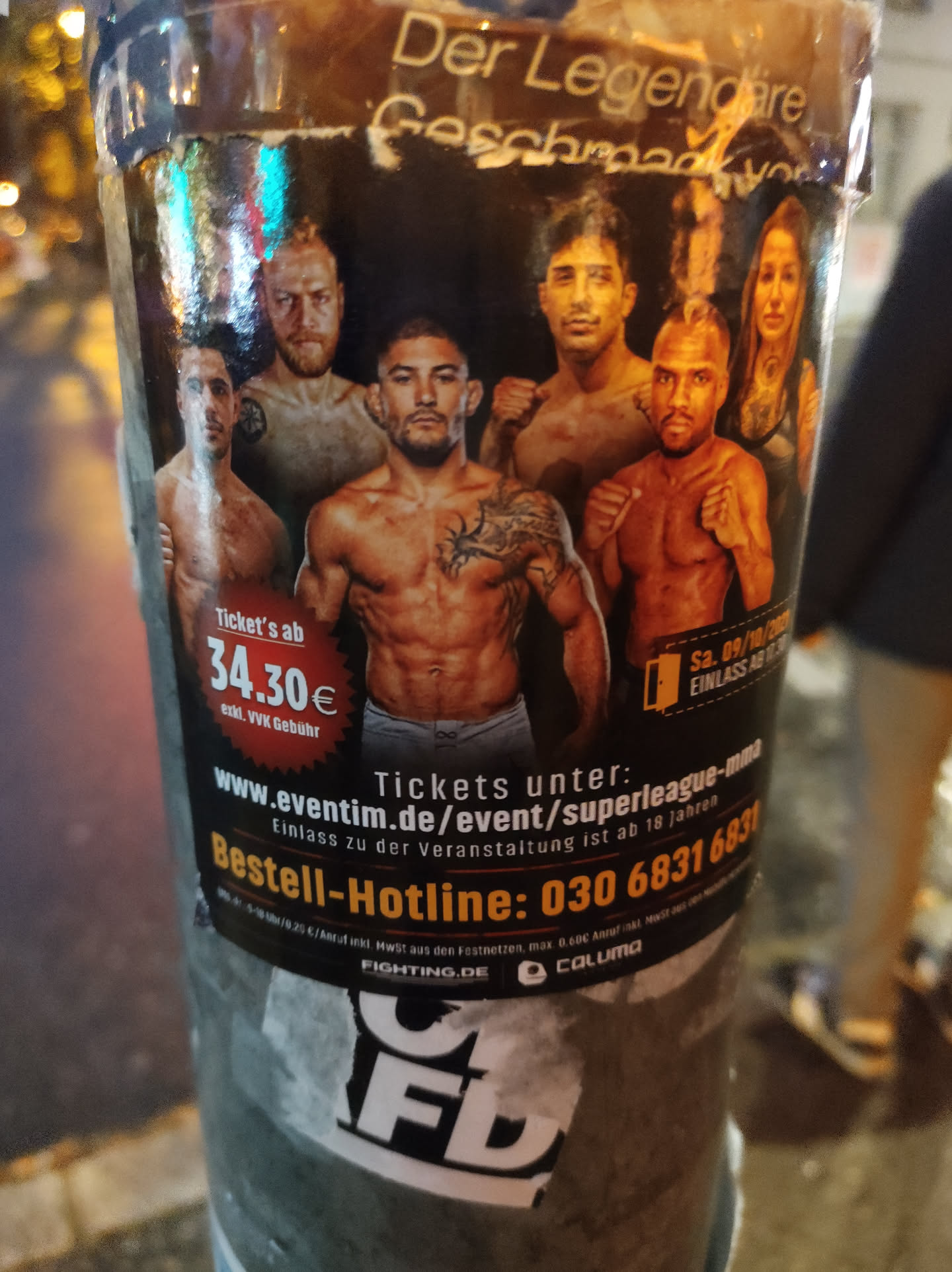 A sticker advertising a Superleague MMA event.  The sticker features several fighters and includes ticket information, a hotline number, and website URL. The logo for the event and the sponsoring company are displayed at the bottom.