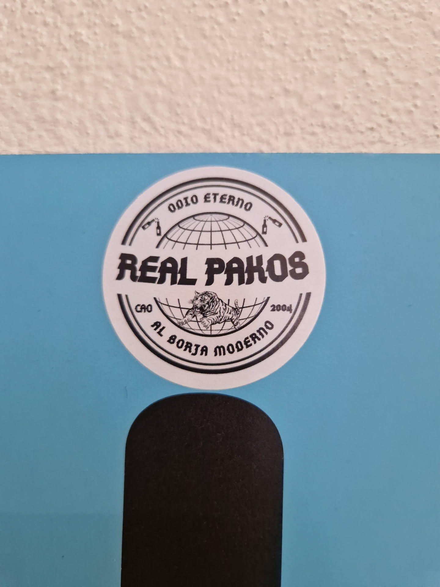 Round sticker with black and white design. It features a globe, text that says "Real Pakos", and other text around the globe that says "Odio Eterno", "2004", and "Al Borja Moderno".