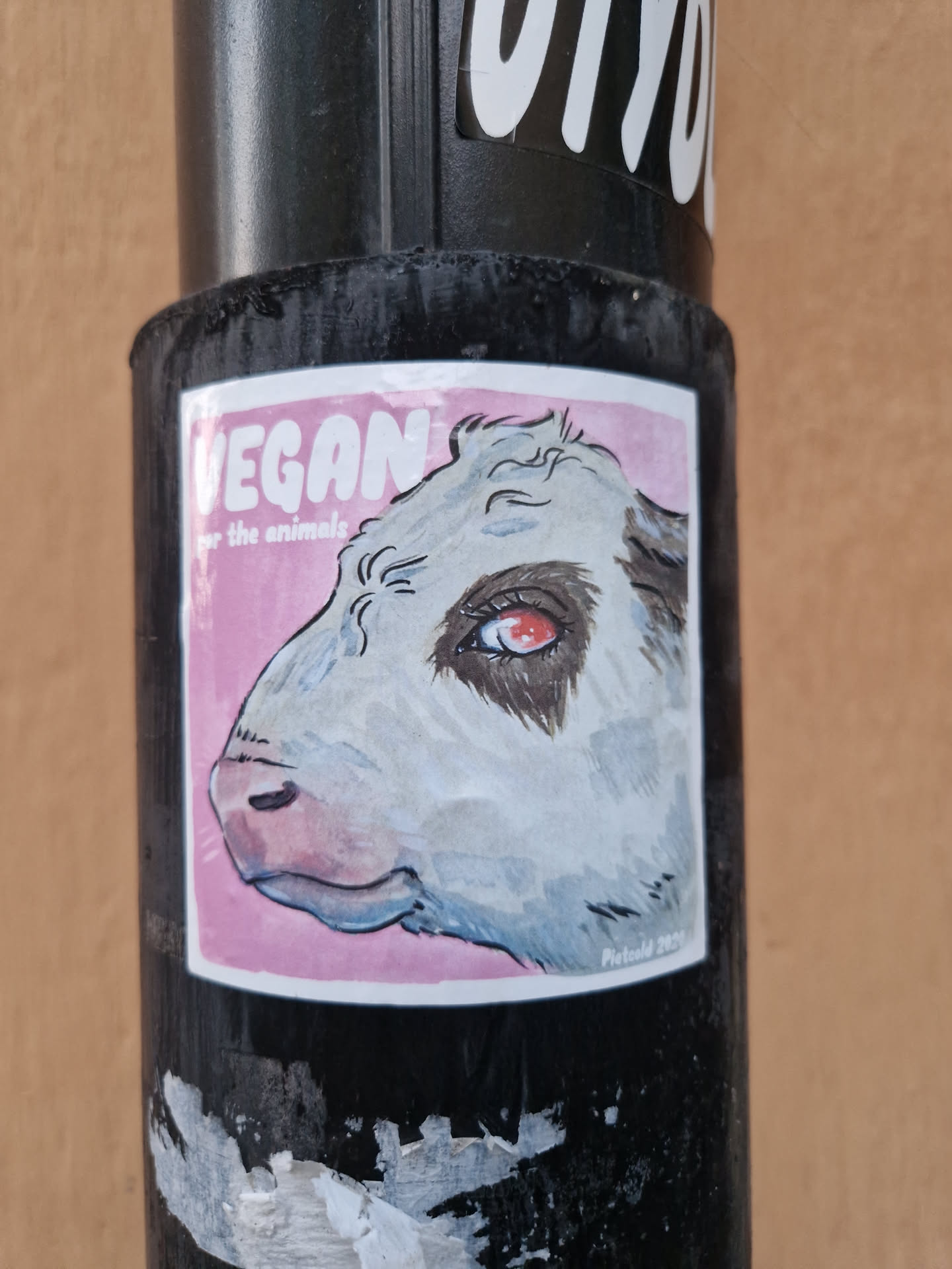 A sticker featuring a stylized illustration of a calf's head against a pink background. The text 'VEGAN for the animals' is prominently displayed. The artist's signature or watermark is visible in the lower right corner.