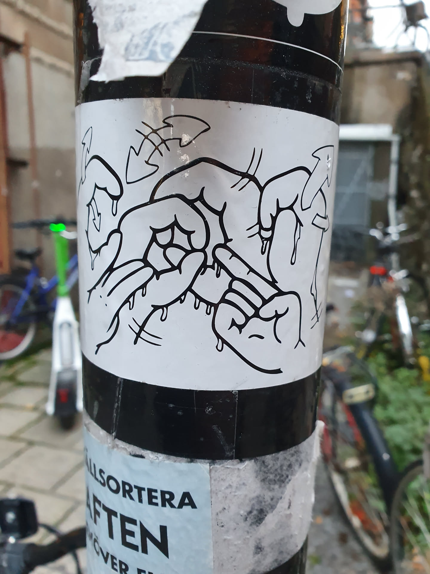 A sticker featuring a black and white illustration of four hands seemingly interacting or performing an action.  The hands are drawn in a simple style with a dripping ink effect, adding a sense of movement and energy.  Arrows suggest a cyclical or repetitive action. 