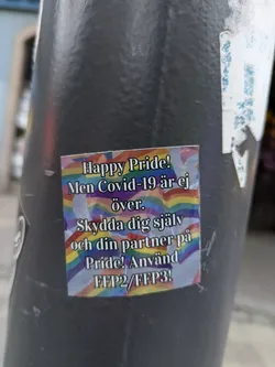 A sticker with a rainbow flag background promoting safe practices during Pride. The text is in Swedish.  It advises using FFP2/FFP3 masks to protect oneself and one's partner.