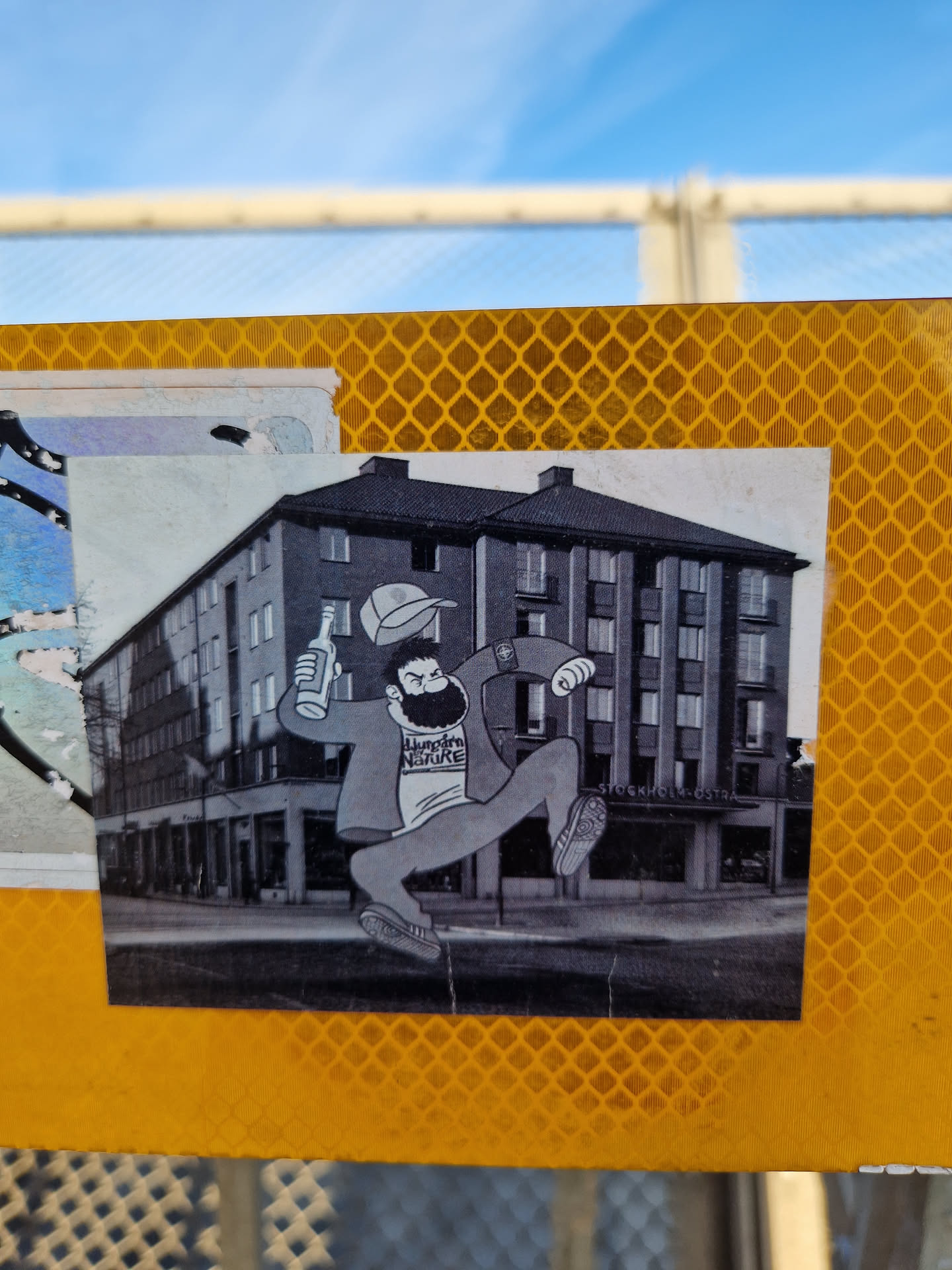 This sticker features a cartoon-like drawing of a man joyfully leaping in front of what seems to be a hotel. The style is reminiscent of vintage illustrations or comic strips. The man is depicted with a beard, a cap, and what looks like a bottle in his hand. The background is a grayscale image of a building named "Stockholmshotellet".