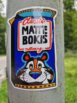 A sticker featuring Tony the Tiger from Frosted Flakes, reimagined with a tattooing theme. The text 'Classic Matte Bokis Tattooing' is prominently displayed.