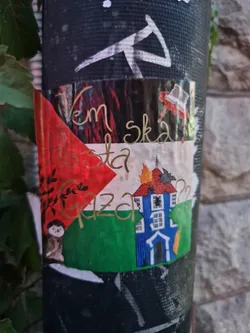 Sticker expressing support for Gaza, featuring a stylized Palestinian flag with a burning house and other images. The text includes 'Gaza' and other illegible words.