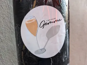 Round sticker with illustration of a champagne glass and a spoon. The text 'A bar called Gemma' is written in a stylized font.