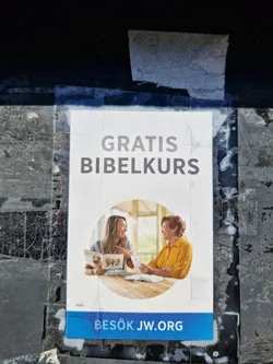 A sticker advertising a free Bible course.  It features an image of two women studying the Bible together and includes a website address.  The text on the sticker is in Swedish.