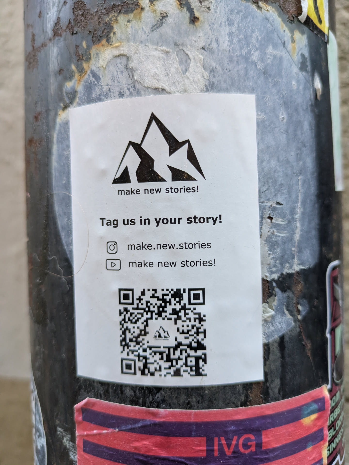A sticker featuring a mountain range logo and a call to action to tag the account in stories.  It includes Instagram and YouTube usernames and a QR code.
