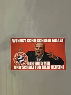 A rectangular sticker with a vibrant red background featuring a prominent image of Uli Hoeneß, a well-known figure from FC Bayern München, in the center. He is depicted with an open mouth and both hands raised, conveying a passionate or shouting expression. To the left of Hoeneß, the circular FC Bayern München e.V. logo is visible in its classic red, white, and blue (though appearing black in this context) colors. White text in a bold, sans-serif font is placed above and below Hoeneß. The top text reads 'WENNST SCHO SCHREIN MUAST' and the bottom text reads 'GEH HOID MID UND SCHREI FÜR MEIN VEREIN!'. The overall style is direct and impactful, typical of fan merchandise.