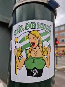 A sticker depicting a blonde woman in a dirndl holding two beer steins, with a flag and the text "Skål för Bajen" (Cheers for Bajen).