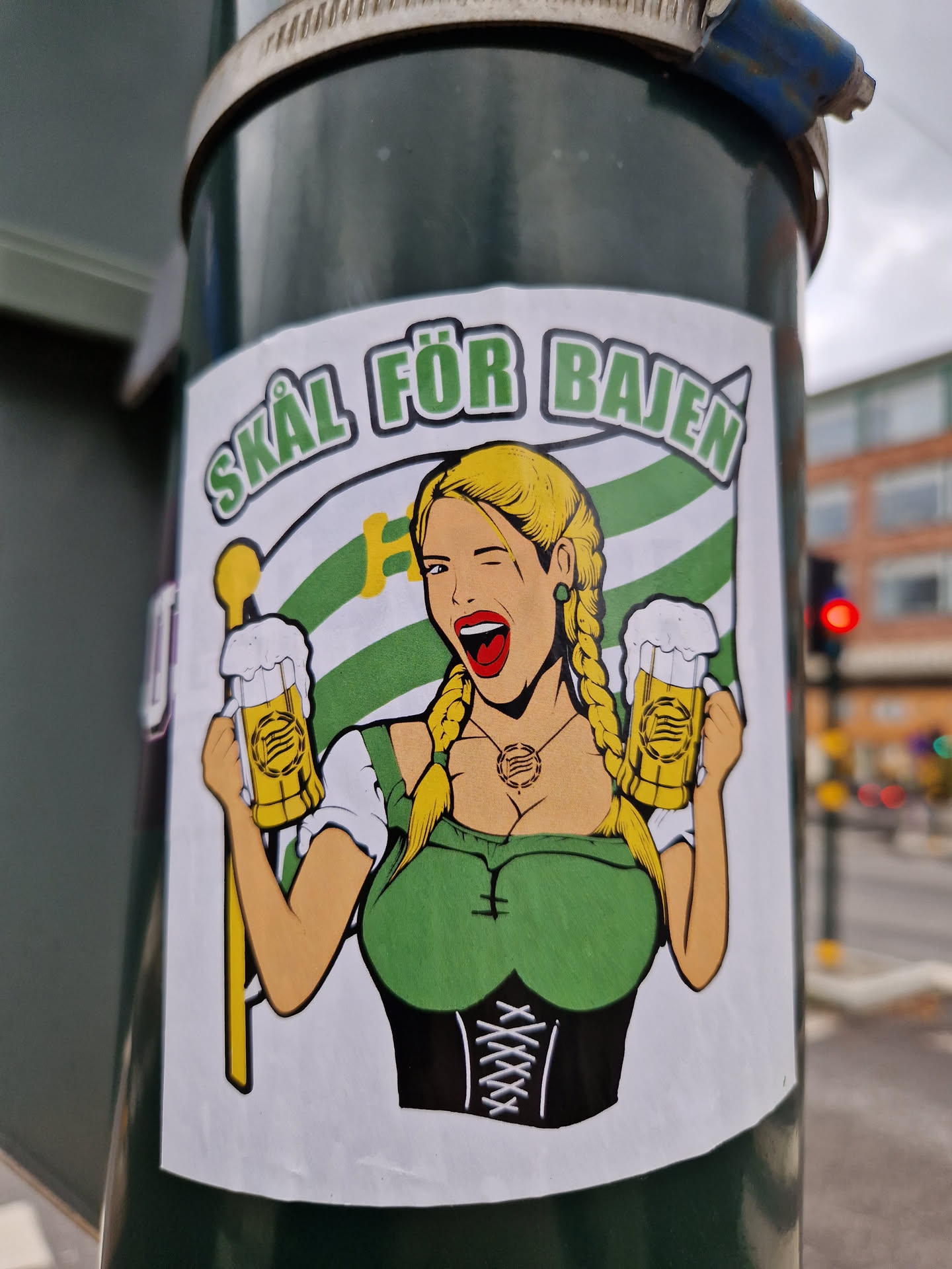 A sticker depicting a blonde woman in a dirndl holding two beer steins, with a flag and the text "Skål för Bajen" (Cheers for Bajen).