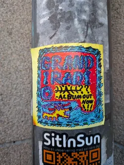 Street sticker A rectangular sticker with a yellow border containing an inner textured frame in blue and black. Inside, a bold red background features chunky, stippled purple and blue lettering reading 'GRAND IRADIO'. Below the main title is handwritten text stating 'HALL??' alongside '-ALBUM OUT NOW!!!'. The bottom section depicts a stylized, colorful creature in yellow, purple, and red set against a blue speckled background.