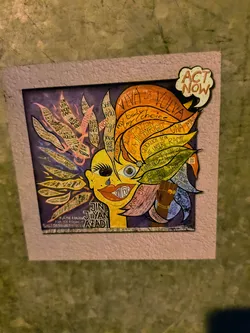 This sticker features a mixed-media portrait with half of the face in yellow tones and the other in purples and blues. The artwork includes empowering phrases like "Viva la Vulva," "my body my choice," and "Education is a human right" integrated into the design. A speech bubble says "Act Now!", emphasizing the call to action. The image is framed with a textured, pink-colored border, giving it a crafted, artistic feel.