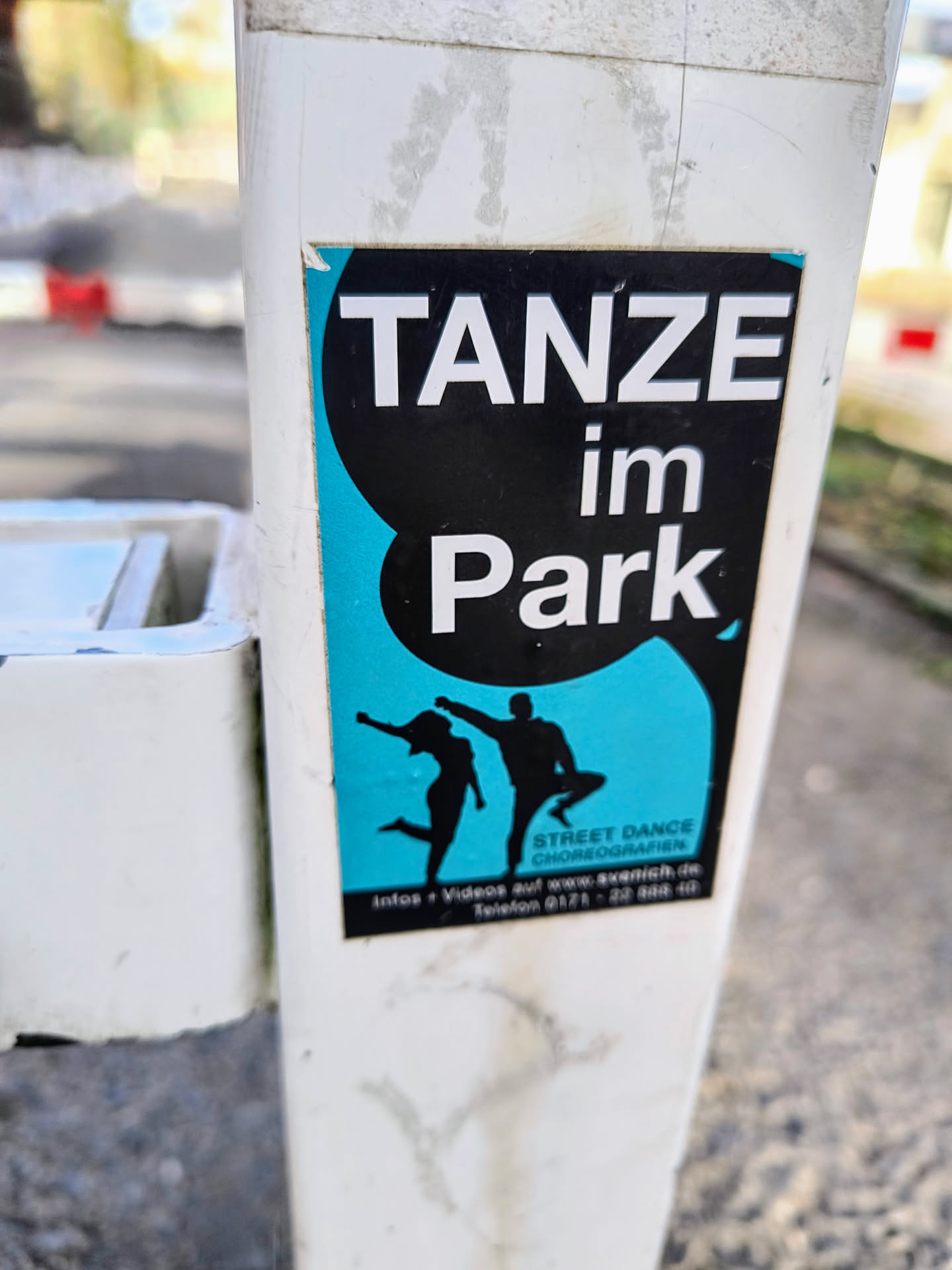 A sticker advertising street dance choreographies in the park.  It features a graphic of two dancers and contact information. The text 'TANZE im Park' is prominently displayed.