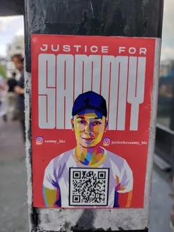 A sticker featuring an illustration of Sammy, with a QR code linking to more information. The sticker advocates for justice for Sammy.