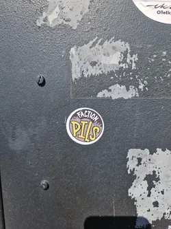Round sticker with the text \"Faction Pills\" in yellow on a dark background with a mountain graphic. 