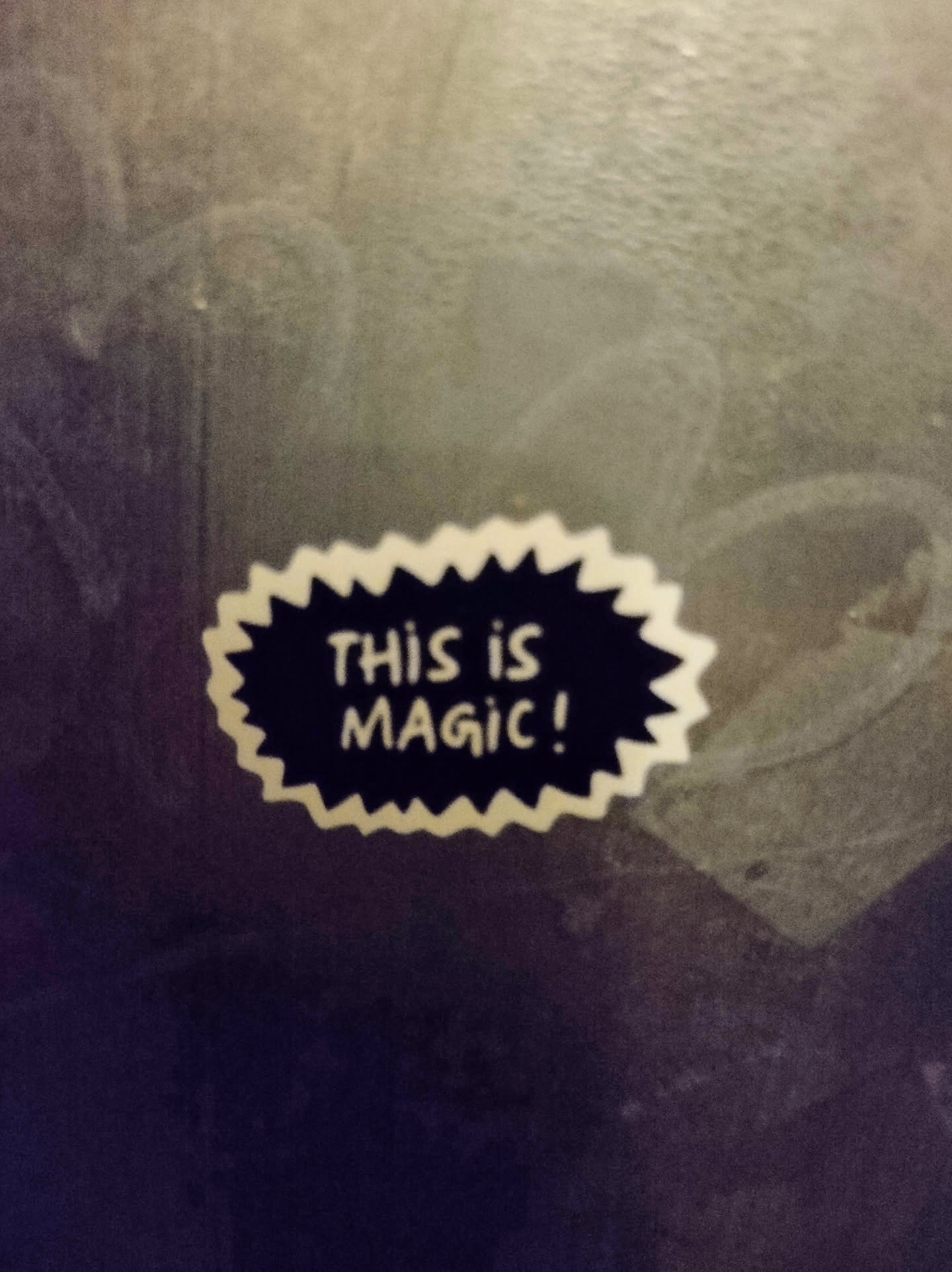 A sticker with a speech bubble shape, with the text "This is magic!" in a retro comic style. It is white with black text and a jagged edge.
