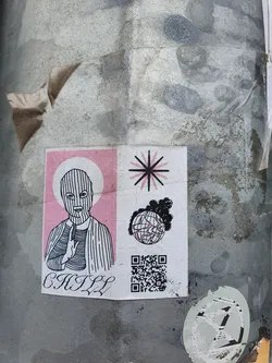 A sticker featuring a stylized illustration of a person wearing a balaclava, making a gesture resembling prayer or meditation.  The background features a pink panel and symbols including a starburst and a burning globe. A QR code is present at the bottom.