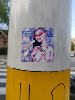 Sticker featuring an illustration of a topless woman with red sunglasses and jewelry. The background is a watercolor-like purple and blue design. The text 'Not asking for it' is prominently displayed on the sticker.