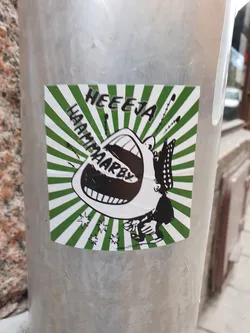 A sticker featuring a cartoon illustration of a large mouth with the text "HEEEJA HAAMPAARBY!" in a green and white sunburst design. The style is reminiscent of vintage comics or pop art.