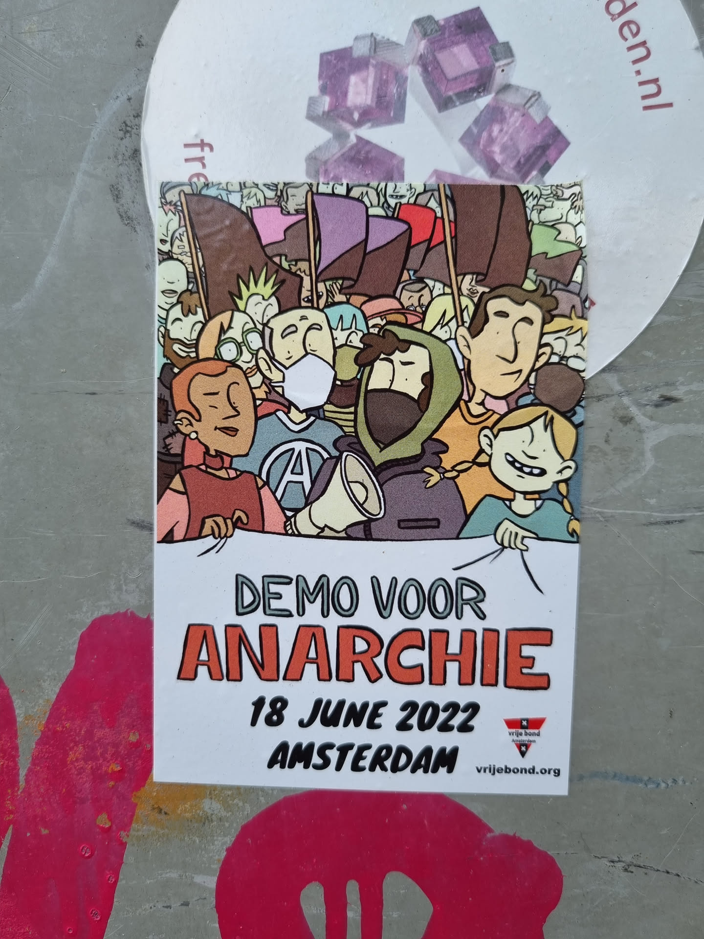 Sticker depicting a cartoon illustration of a demonstration for anarchy in Amsterdam on June 18, 2022. The illustration shows a crowd of people holding flags and banners.  The sticker includes the text "Demo voor Anarchie," "18 June 2022," and "Amsterdam." A website address is also present at the bottom.
