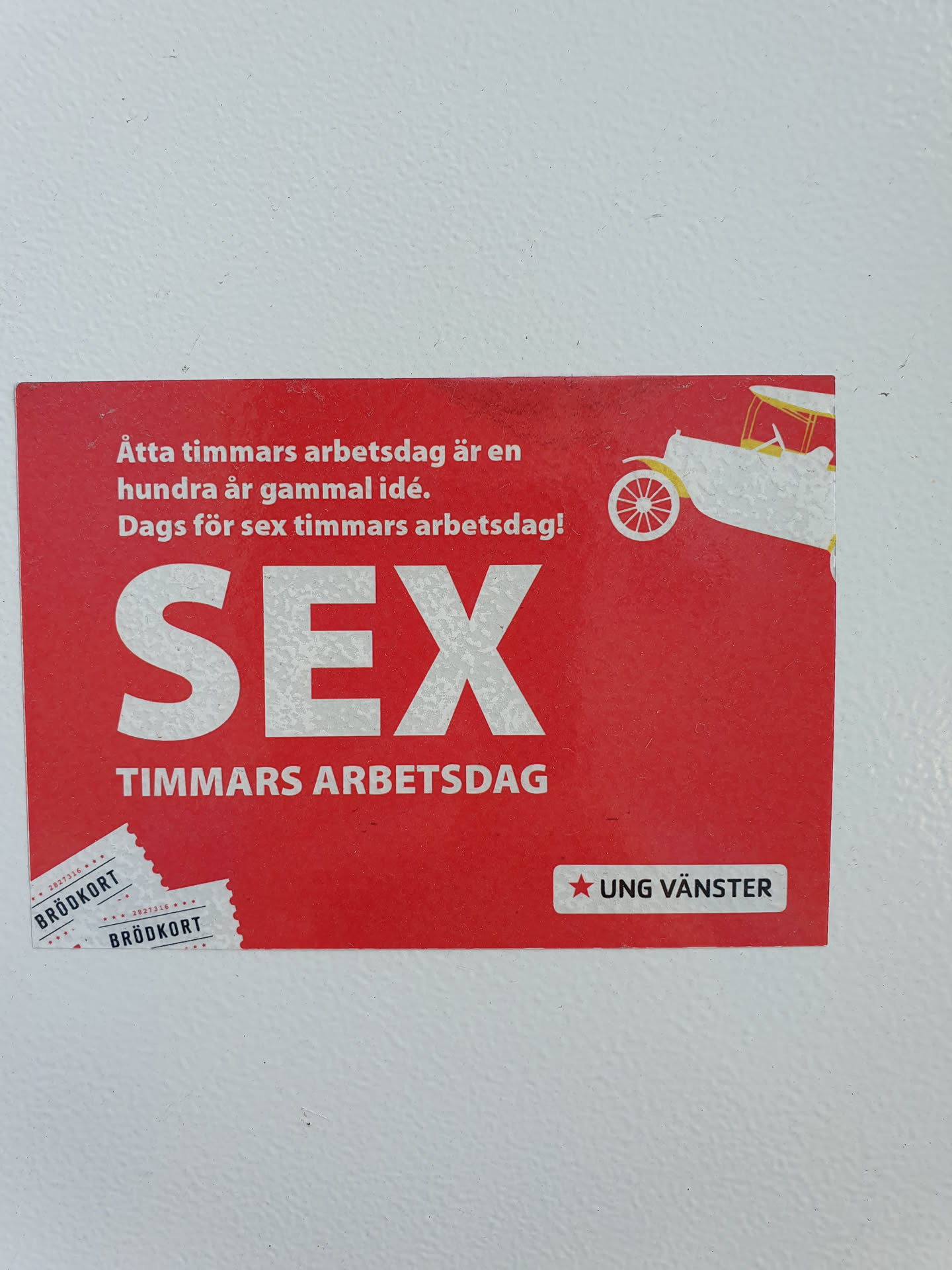 A red sticker advocating for a 6-hour workday.  It features an illustration of a vintage car and text in Swedish.  The sticker is from Ung Vänster (Young Left).