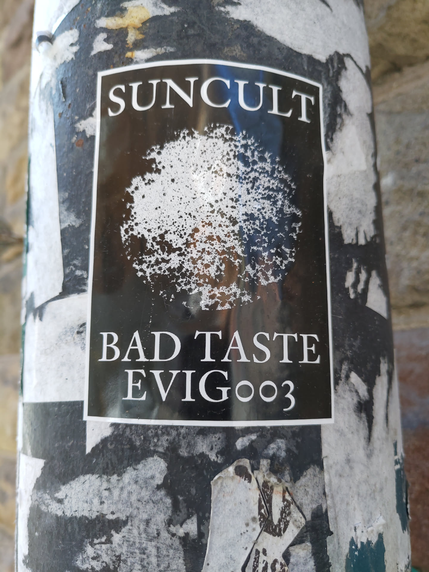 Black and white sticker with a tree-like image and text. The text on the sticker says "SUNCULT" at the top and "BAD TASTE EVIG003" at the bottom.