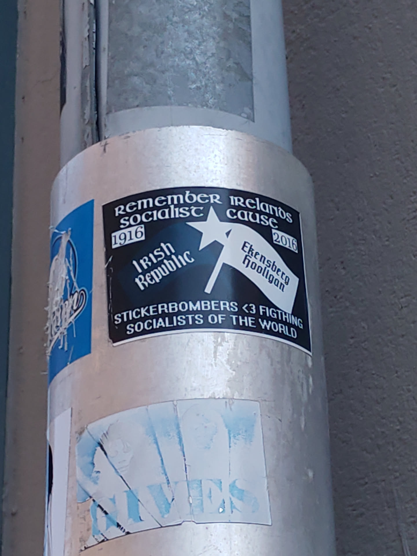 A sticker commemorating the Irish socialist cause from 1916 to 2016. It features the Irish Republic flag and text mentioning Ekensberg Hooligan and Stickerbombers. The sticker also contains a message of solidarity with fighting socialists of the world.