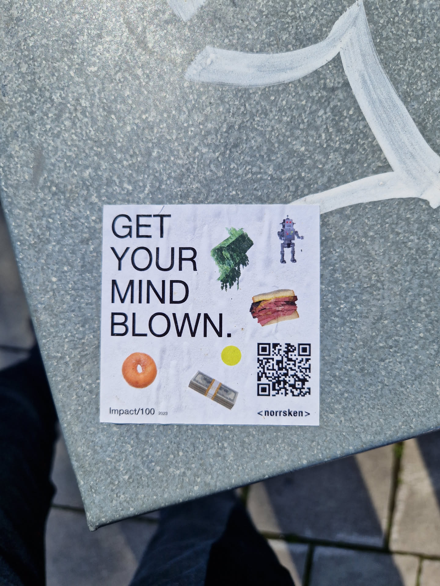 A sticker featuring the text 'GET YOUR MIND BLOWN.', along with illustrations of a robot, a sandwich, a bagel, a stack of money, and a QR code. The sticker also includes the text 'Impact/100' and '<norrskn>'.