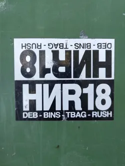 A black and white sticker with the text "HNR18" prominently displayed.  Smaller text at the top and bottom reads "DEB - BINS - T BAG - RUSH".