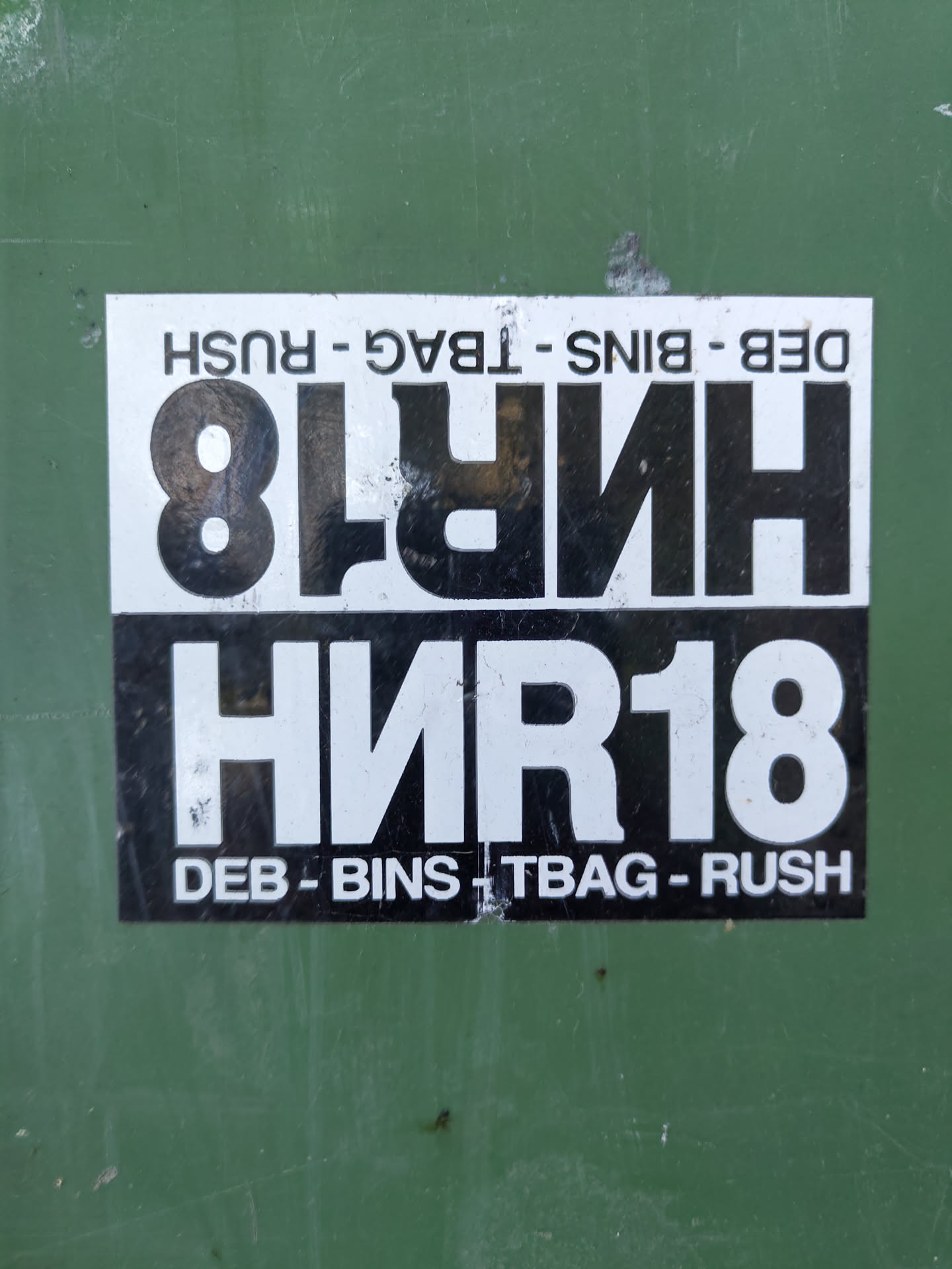 A black and white sticker with the text "HNR18" prominently displayed.  Smaller text at the top and bottom reads "DEB - BINS - T BAG - RUSH".