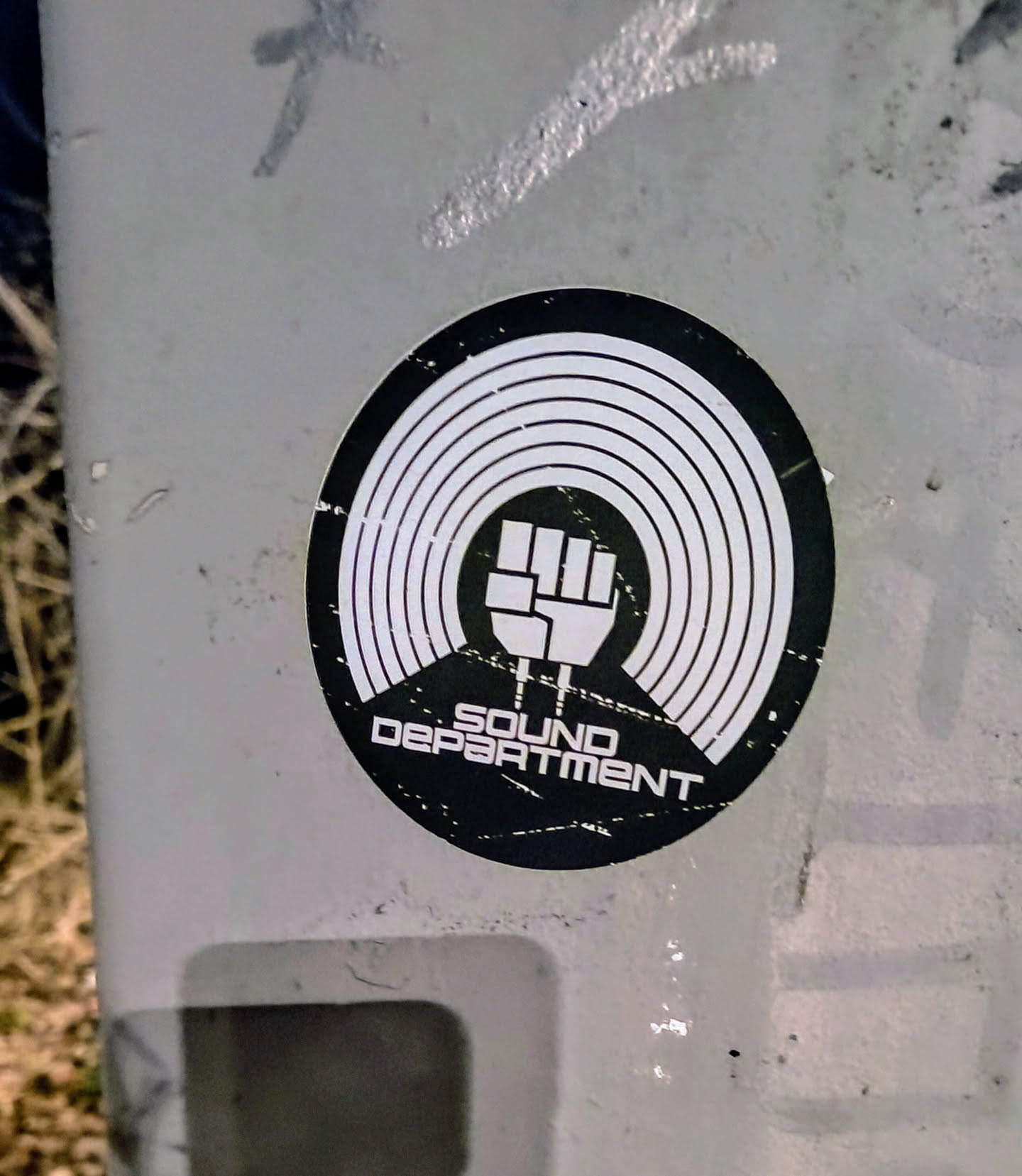 Black and white round sticker with a vinyl record design and a fist in the center. The text "SOUND DEPARTMENT" is written below the fist.