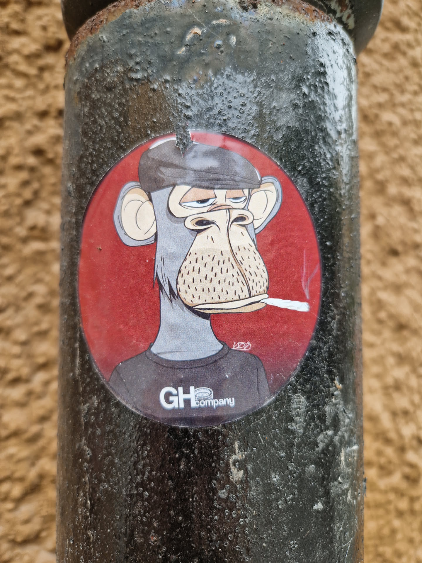 A round sticker featuring a cartoon illustration of a monkey wearing a beret and smoking a cigarette. The monkey has a relaxed expression and is set against a red background. The sticker has the logo 'GHcompany' at the bottom.