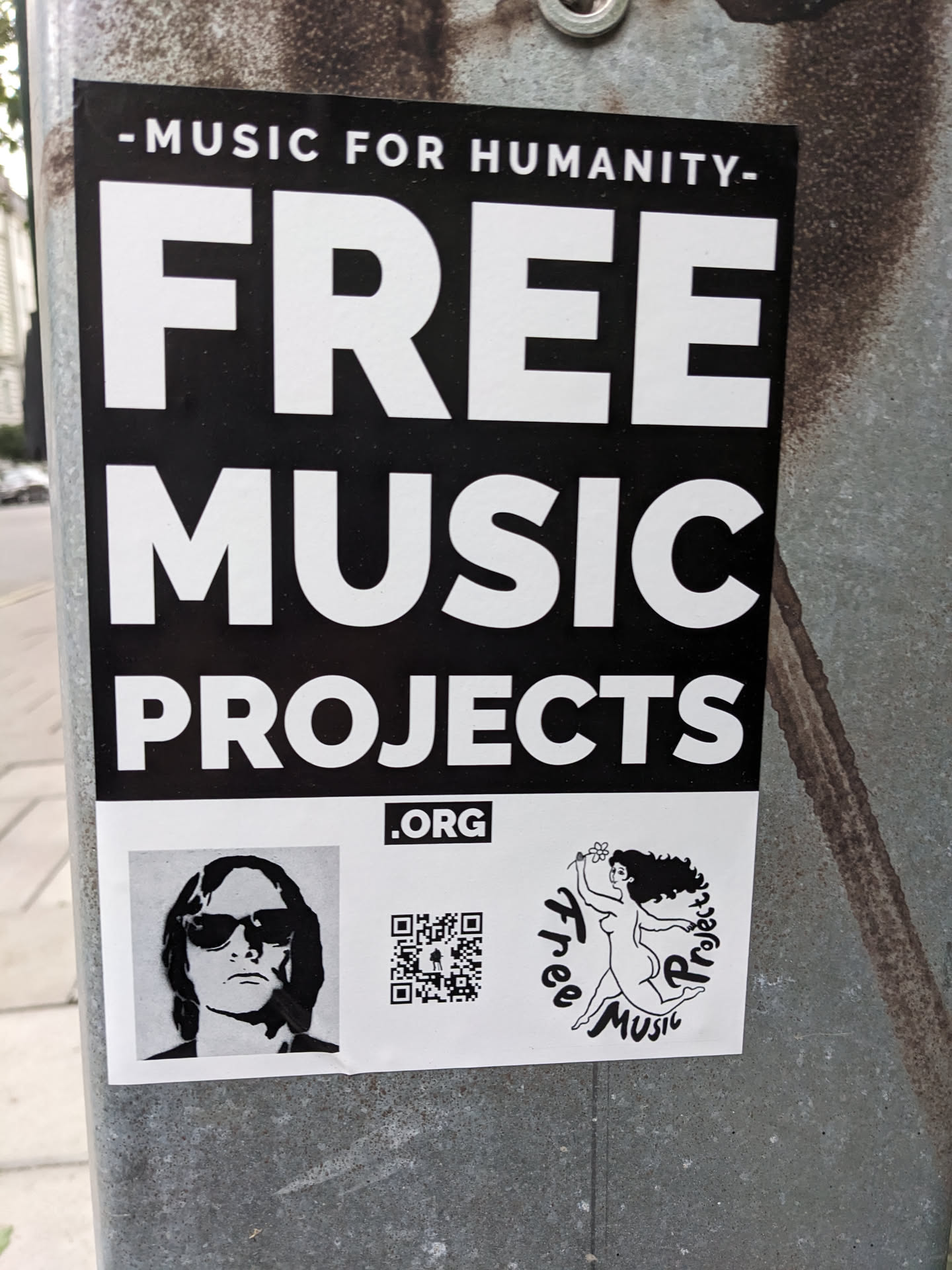 Sticker promoting Free Music Projects, an organization dedicated to providing free music. The sticker features a QR code, a black and white portrait, and an illustration of a woman. The main text on the sticker states "Free Music Projects.org".