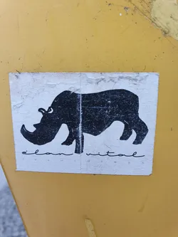 A sticker featuring a simple black silhouette of a rhinoceros.  The text 'elan vital' is printed beneath the image.