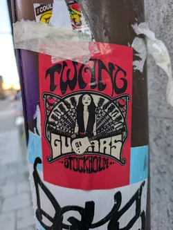 Red sticker featuring a woman playing guitar with an illustration style reminiscent of 60s/70s psychedelic rock posters. The text 'Twang Guitars' is prominently displayed, along with the city name 'Stockholm'.