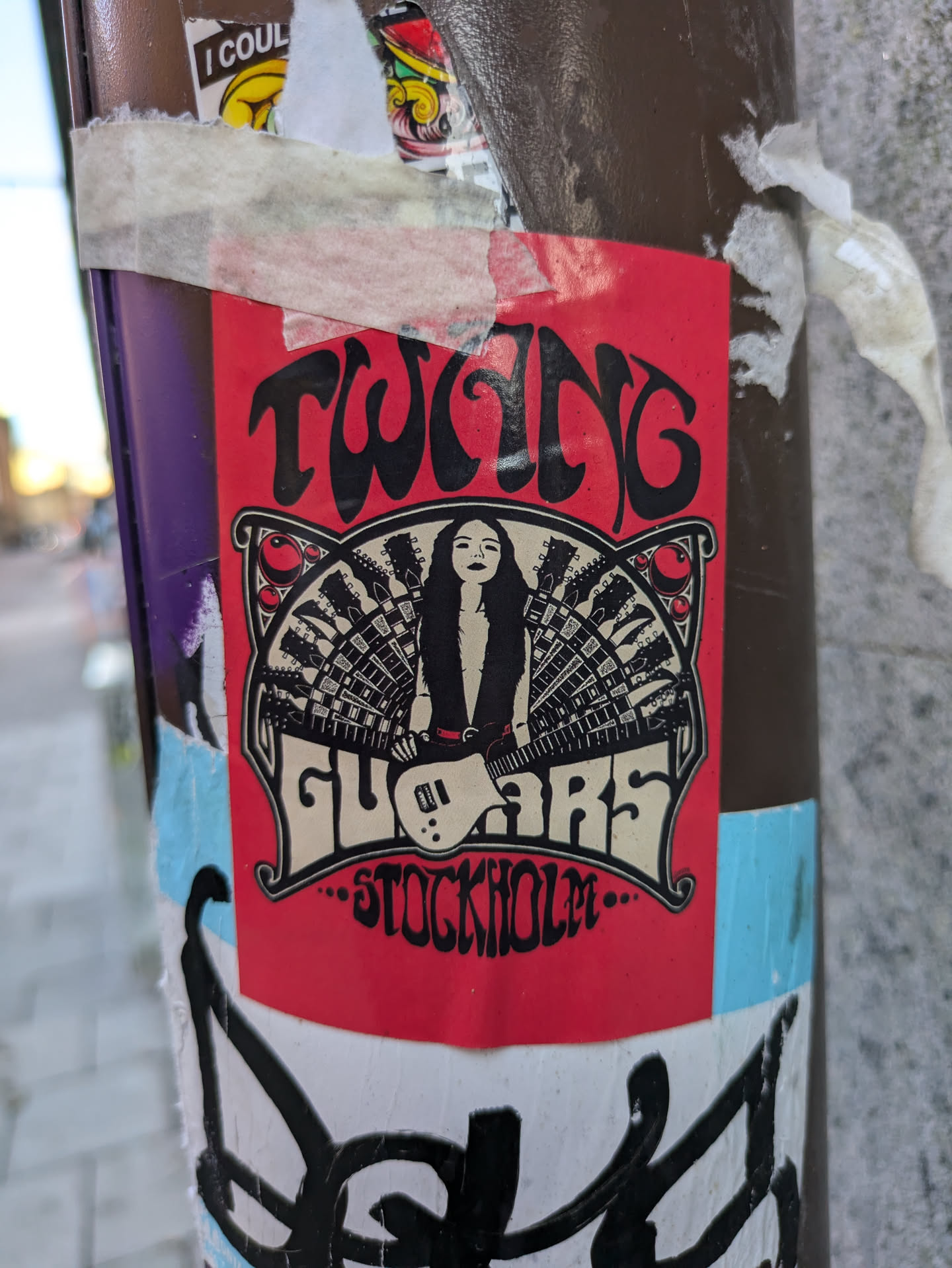 Red sticker featuring a woman playing guitar with an illustration style reminiscent of 60s/70s psychedelic rock posters. The text 'Twang Guitars' is prominently displayed, along with the city name 'Stockholm'.