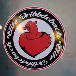 Round sticker featuring a red stylized bird illustration resembling a rooster or phoenix within a black circular border with the text Dribbdebach Elite written around it.