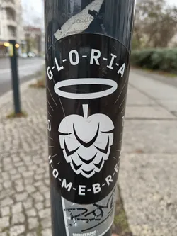 Black and white sticker with the word GLORIA in a stylized font, a hop graphic, and the text HOMEBREW. It's a simple yet striking design, perfect for beer enthusiasts.