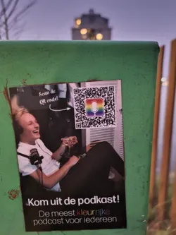 A sticker promoting a podcast. It features a picture of a person holding a drink and a microphone, and a QR code. The text on the sticker says "Scan de QR code!" and "Kom uit de podkast! De meest kleurrijke podcast voor iedereen", which translates to "Scan the QR code!" and "Come out of the podcast! The most colorful podcast for everyone".