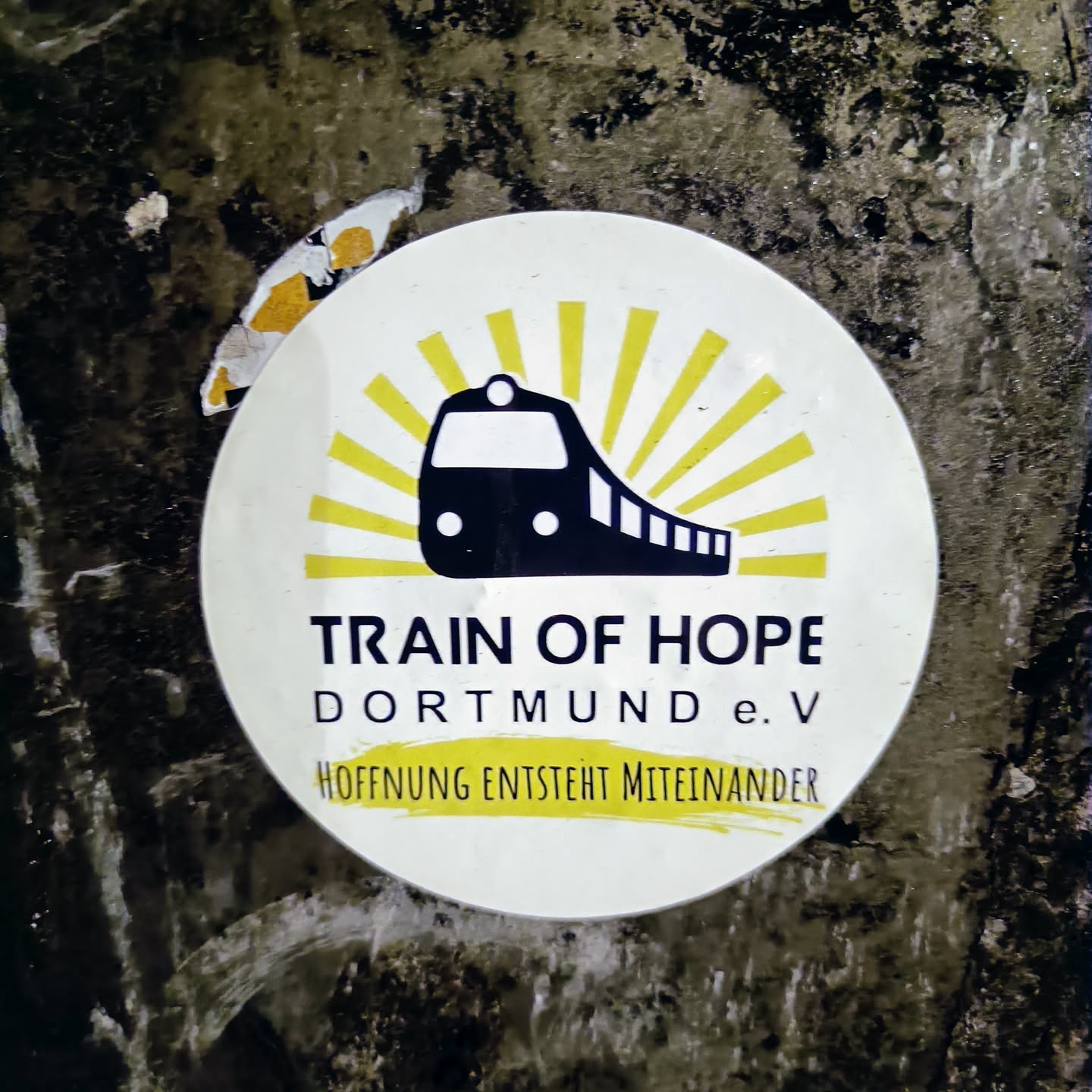 Round sticker featuring a train and sunburst design. Text includes 'Train of Hope Dortmund e.V' and 'Hoffnung entsteht miteinander'.